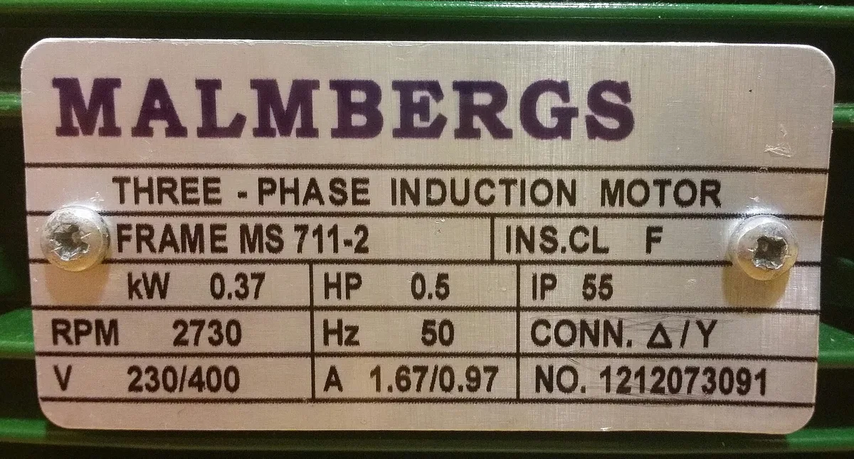 Close-up of a three-phase induction motor rating plate showing manufacturer, frame, power, voltage and serial number.